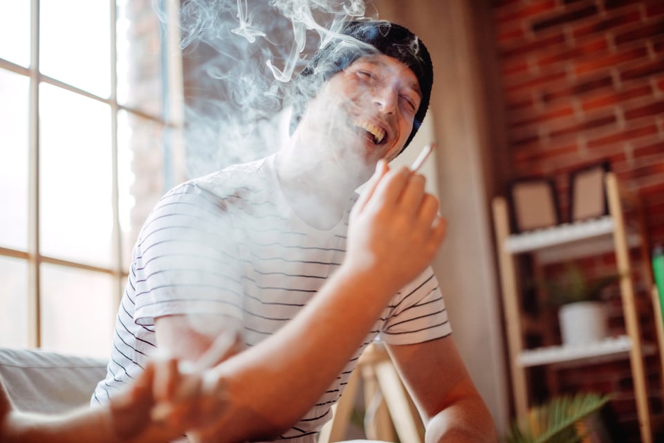 Laughing man smoking marijuana
